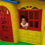 Criança na janela da casinha em buffet infantil Zona Norte SP
